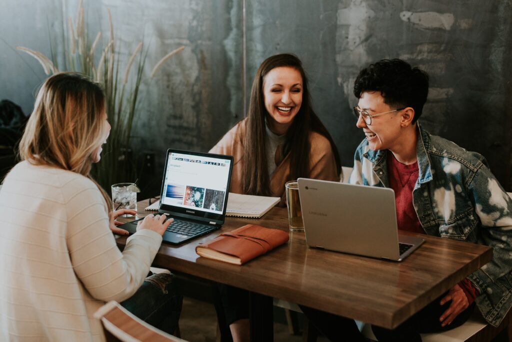 Three colleagues sitting around a table working and having fun