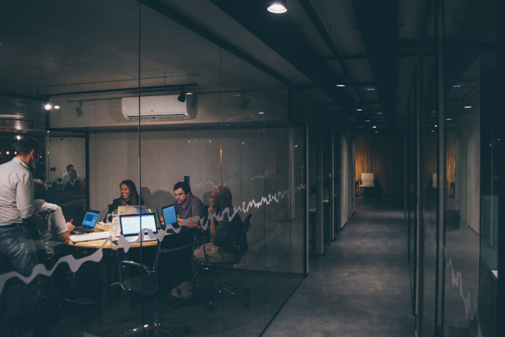 A meeting between 5 colleagues in an industrial style office