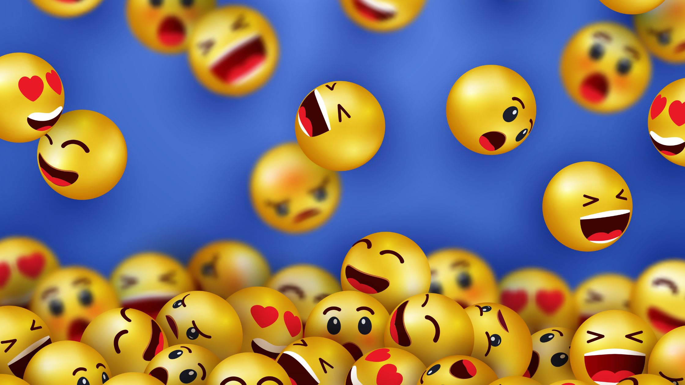 Yellow round smiling and angry emojis falling from the sky against a blue background